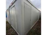 a large white container sitting on top of a grass covered field