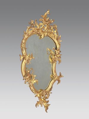 un miroir orné d'un cadre doré, décoré d'oiseaux et de fleurs