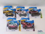 cinq petites voitures Hot Wheels exposées sur la table