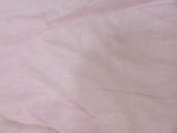 a close up of a bed with a pink comforter on it