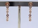 earrings with pearls and diamonds on a stand on a white background