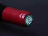 a close up of a bottle of wine with a red cap