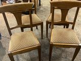 four wooden chairs with woven seats in a store