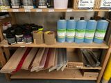 a shelf with many different types of paint and supplies on it