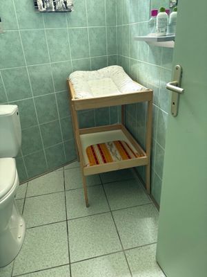 une petite salle de bains avec des toilettes, un lavabo et un porte-serviettes