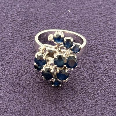 silver ring with blue stones on a purple surface