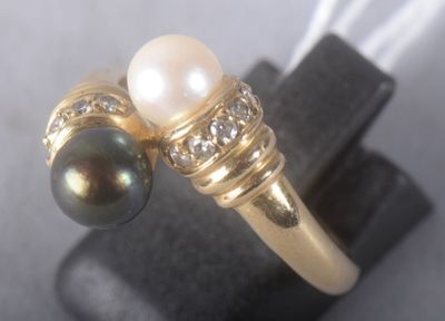 bague en or ornée de perles et de diamants, exposée sur un fond noir