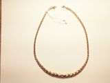 a close up of a gold necklace on a white surface