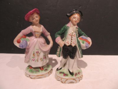 two figurines of a man and a woman standing next to each other