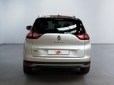 the rear end of a silver car in a room with a white wall