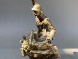 figurine of a soldier on a rock with a gun