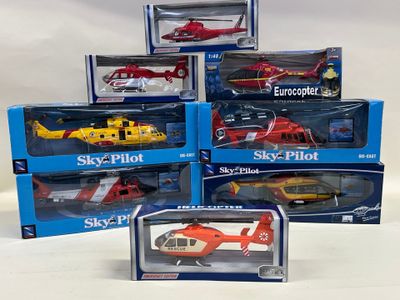 six hélicoptères miniatures assortis, dans leurs boîtes, posés sur une surface blanche