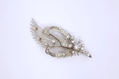 a close up of a silver brooch with a flower on it