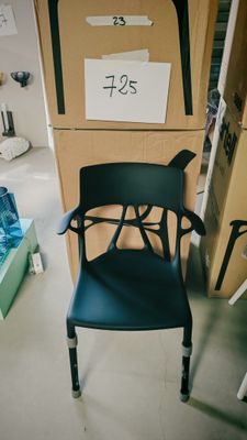 une chaise noire posée devant une pile de cartons