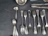 a lot of silver spoons and spoons on the table