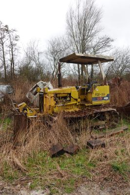 un bulldozer jaune garé au milieu d'un champ