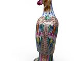 a colorful vase with a bird on it on a white surface