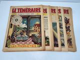 three old french comic books on display on a table