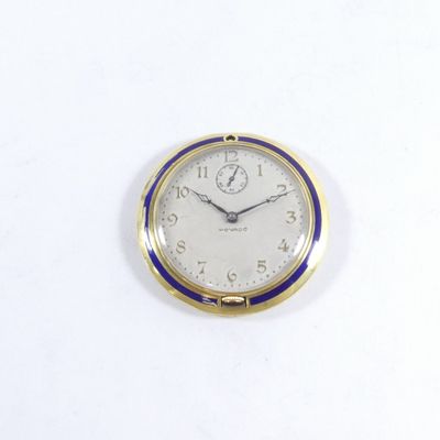 une horloge dorée et bleue sur un fond blanc
