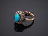 a gold ring with a turquoise stone surrounded by diamonds