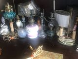 a desk with a lamp, a book, a lamp, and other items on it