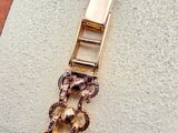 a gold bracelet that has a chain on it