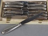 six knives in a wooden box with a knife on top of it