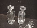two clear glass bottles sitting next to each other on a table