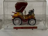 a toy car in a clear box on a white surface