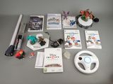 une table sur laquelle se trouvent un volant, un jeu Wii et d'autres objets