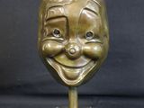 bronze statue of a smiling face with a hat on top of it