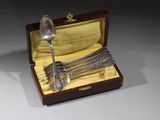 une cuillère en argent et un service de cuillères dans un coffret en bois