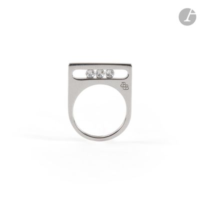 a close up of a ring on a white surface with diamonds