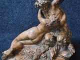 statue of a man and a woman on a rock with a flower in his hand