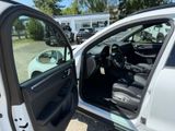 a white car with its door open next to a parking lot