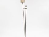 the floor lamp is made of metal and has a beige shade