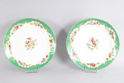 two green and white plates with flowers on them sitting on a table
