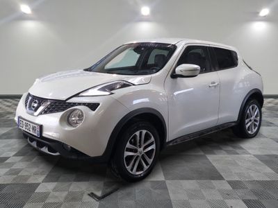 the white nissan juke suv is parked on a checkered floor
