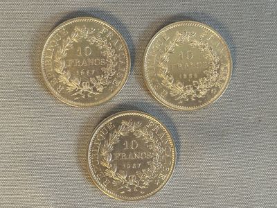 trois pièces d'or posées les unes à côté des autres sur une table