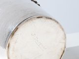 une coupe en argent posée sur une table blanche