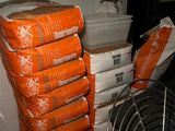 une pile de sacs orange posée sur une pile de cartons blancs