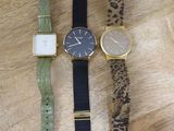 three different watches sitting on a wooden surface with a leopard print strap
