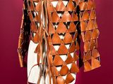 a brown leather jacket with triangles and fringes on a mannequin