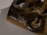 a bronze statue of a man riding a horse on a rock