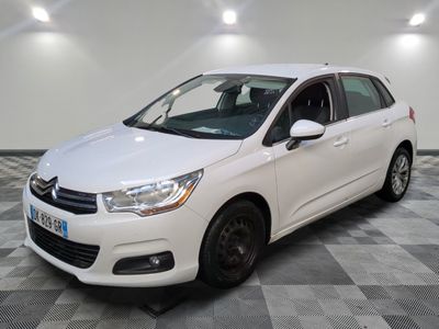 la voiture blanche est garée sur un sol en damier dans le garage