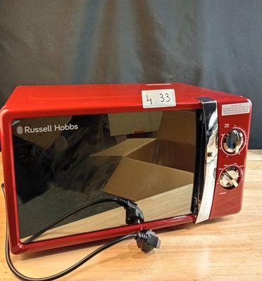 a red microwave oven sitting on a wooden table