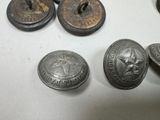 some old metal buttons sitting on top of a white table