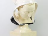 marble bust of a woman wearing a white hat on a marble base