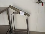 une table en acier inoxydable et un tabouret en métal dans une cuisine