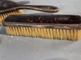 two brushes that are sitting on a table next to a coin